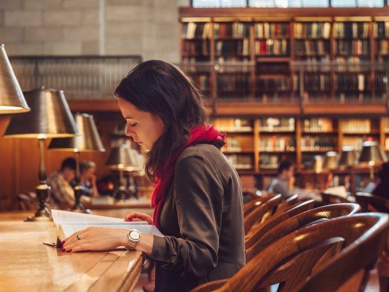 Side shot of a woman reading in a library